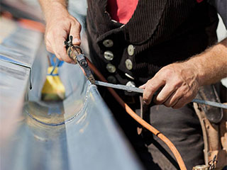 Technician repairing gutters in Austin